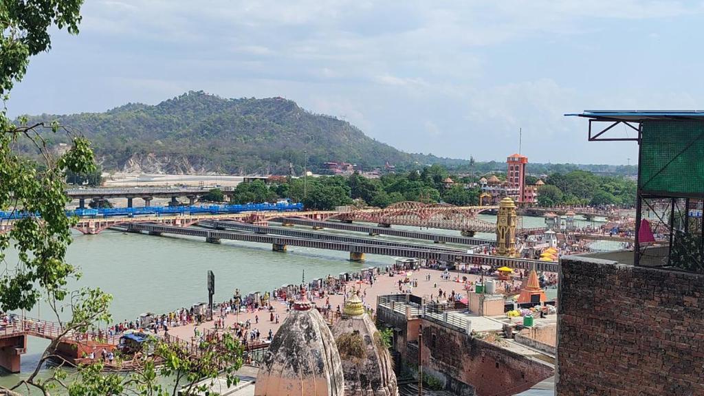 a group of people standing near a body of water at Hotel Har Ki Pauri with terrace Ganga view in Haridwār