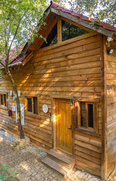 a log cabin with a door and a tree at Colibri - Cabañas Puerto del Zopilote in Pinal de Amoles