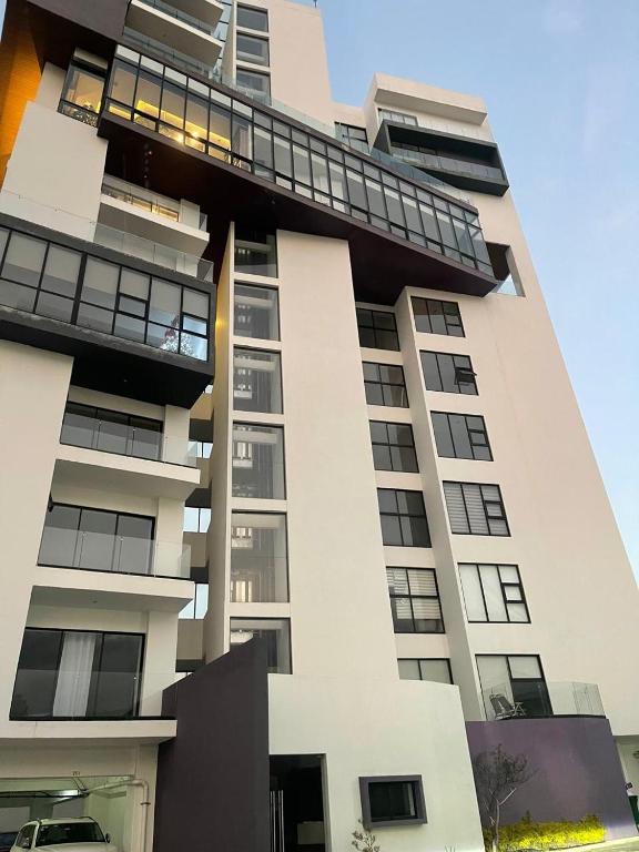 a tall white building with a balcony on it at Departamento Torre el Morado MAS EXPERIENCIA A CABALLO in La Concepción