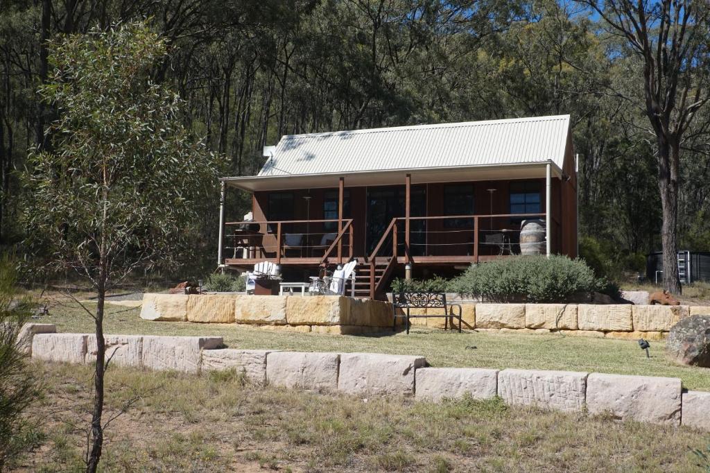 a small house with a porch and a deck at The Cabin at Rocklee Grove in Broke