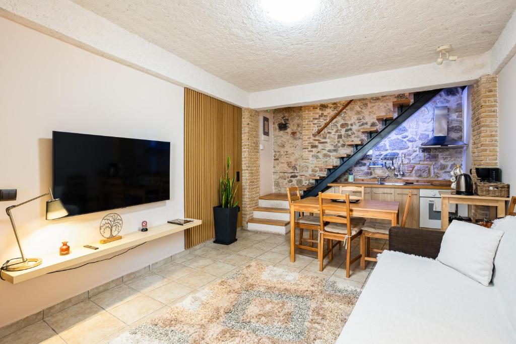 a living room with a large television and a table at Limni Stone Apartments in Límni