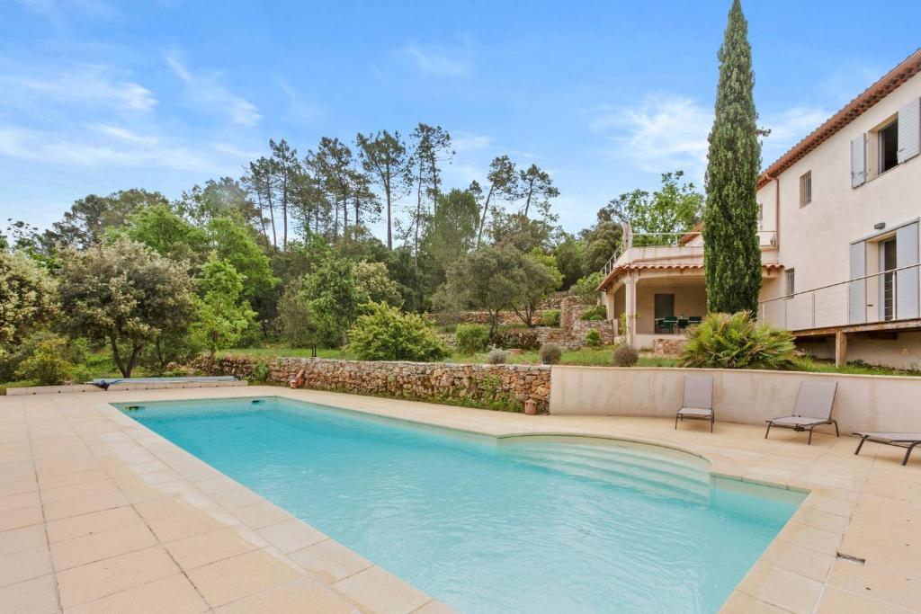 a swimming pool in a yard next to a house at Chambres D’hôte Cotignac in Cotignac