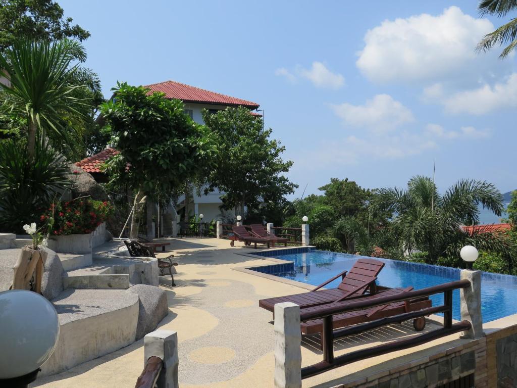 einen Pool mit zwei Liegestühlen neben einem Haus in der Unterkunft Viking House Villa in Ko Tao