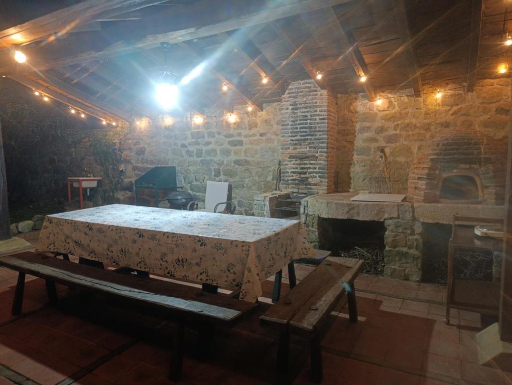 a stone room with a table and a fireplace at Casona de Gómez y Terán in Renedo