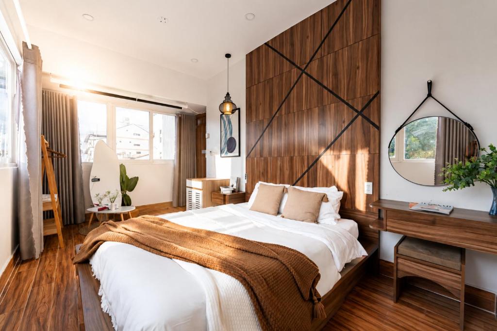 a bedroom with a large bed and a desk at The Morris Central Hotel - O'TEL in Da Lat