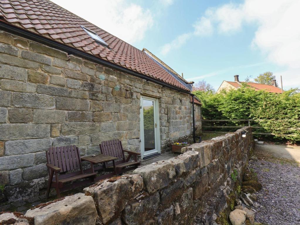 a stone house with a bench and a window at Horseshoe Cottage in Middlesbrough