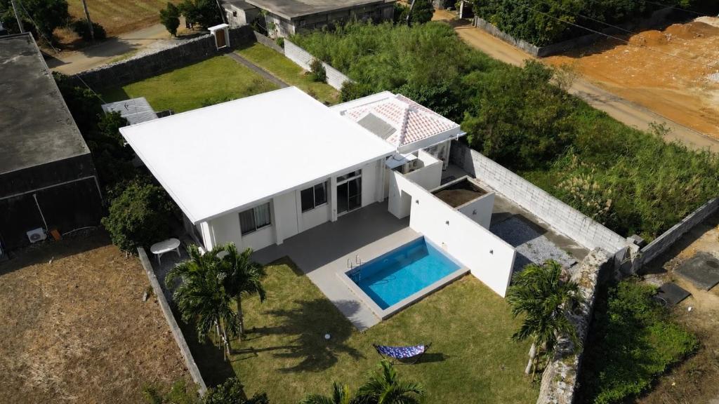 an aerial view of a white house with a swimming pool at ritomaru villa pierce miyakojima in Miyako-jima