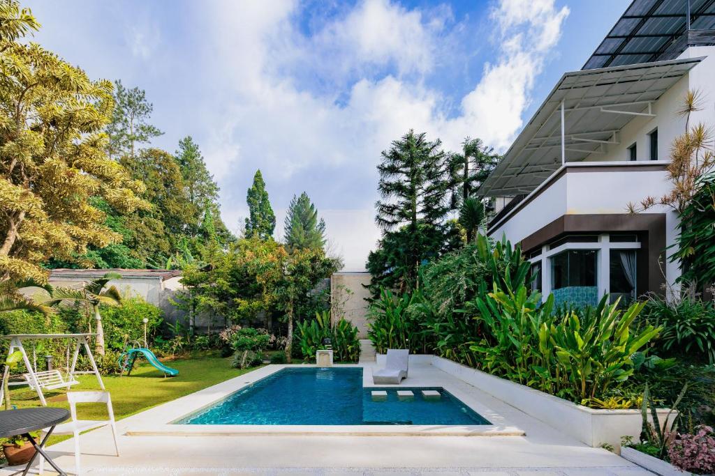 a swimming pool in the backyard of a house at The Lavana Signature Villa Alessa Puncak in Puncak