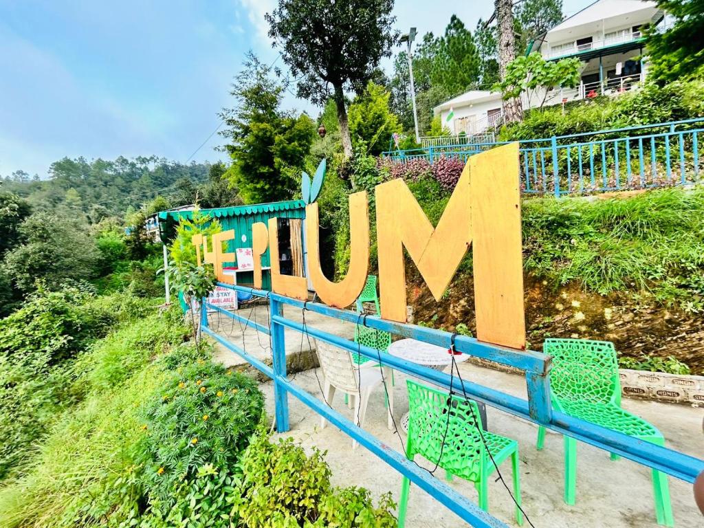 a large sign that saysuman sitting on top of a hill at The Plum in Mukteshwar