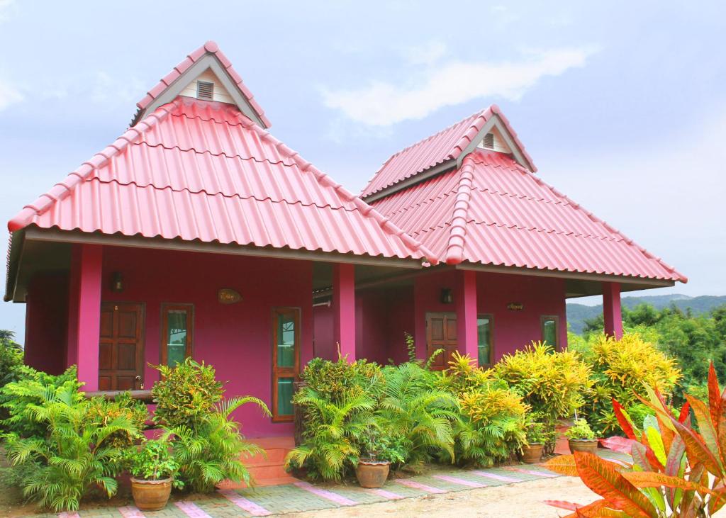 a red house with plants in front of it at Baan Buapatumma in Mae Sai