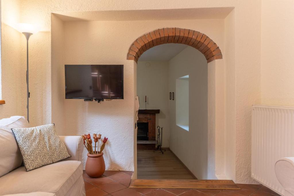 an archway in a living room with a couch and a television at Spacious home near Orta, 8min in Armeno