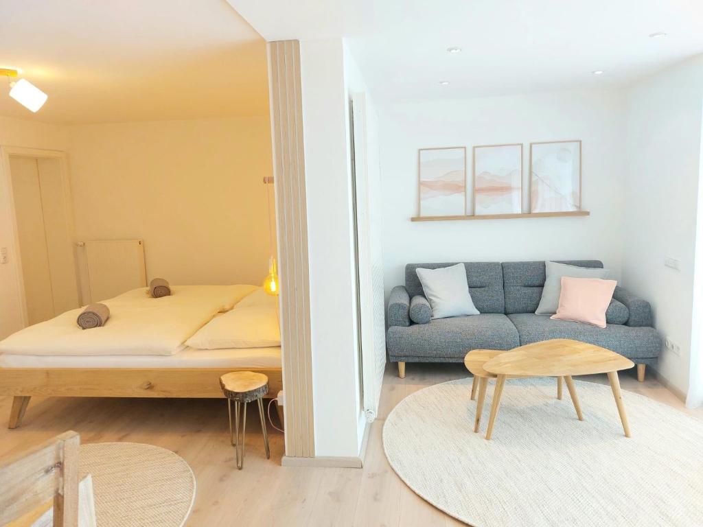a living room with a bed and a couch at Dahoam beim Haas in Rieden