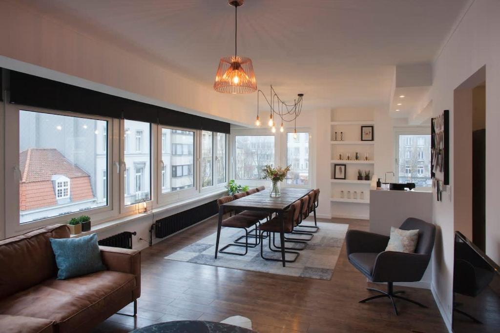 a living room with a couch and a table with chairs at Stylish Central Flat, Steps to Beach in Ostend