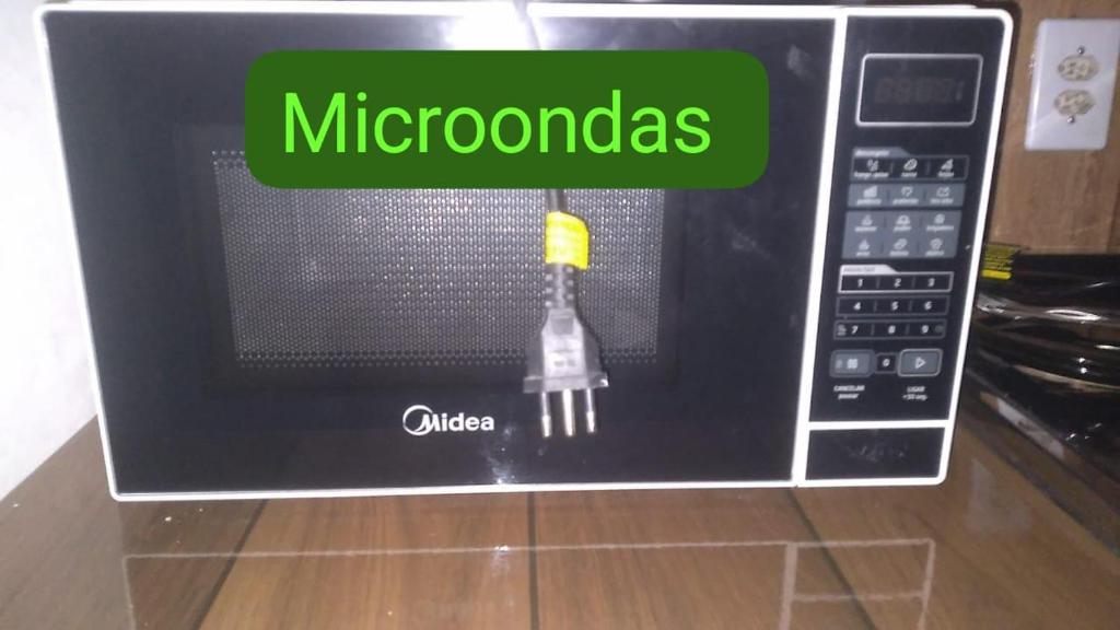 a microwave with a fork inside of it at Suite Love in Paty do Alferes