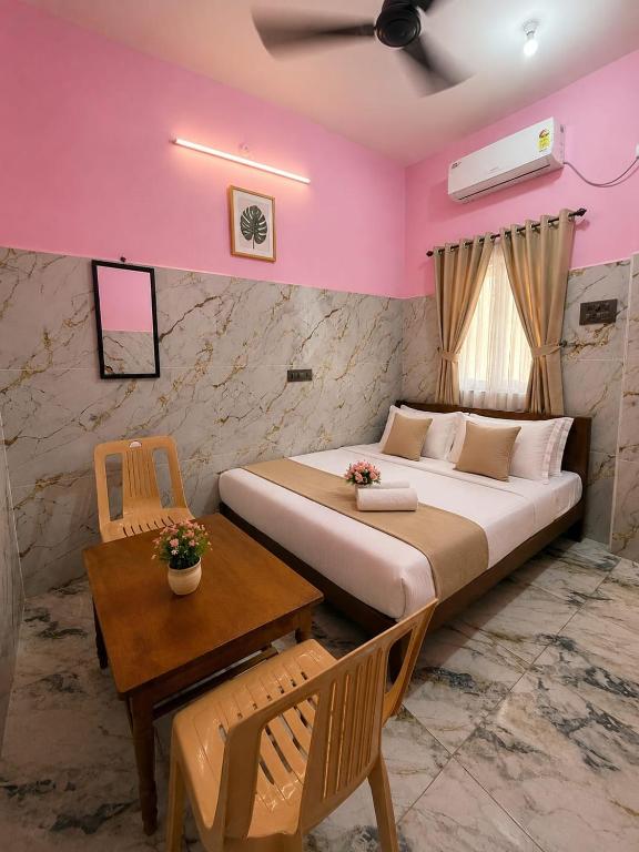 a bedroom with a large bed and a table at G3 house Pondicherry in Pondicherry