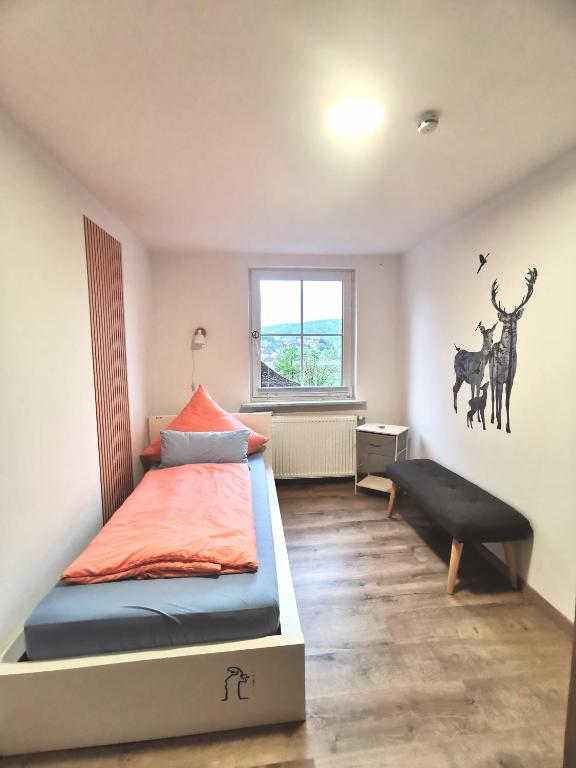 a bedroom with a bed and a bench in it at Lier Stays in Meschede