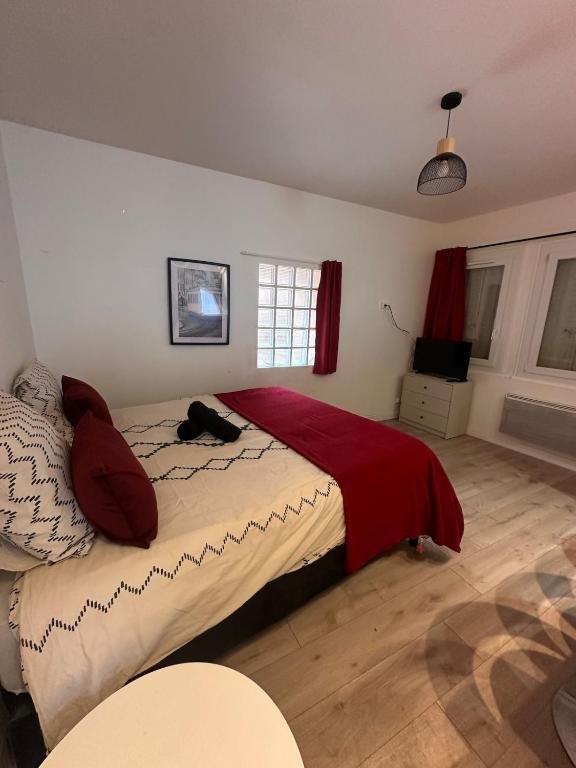 a bedroom with a bed with a red blanket at L'Essentiel de Paray in Paray-le-Monial