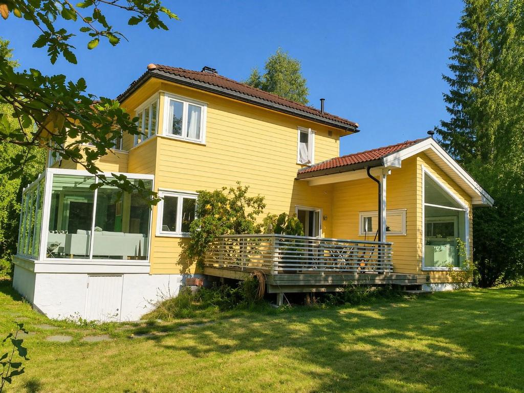 a yellow house with a large front porch at Spacious Villa in Lillehammer in Lillehammer