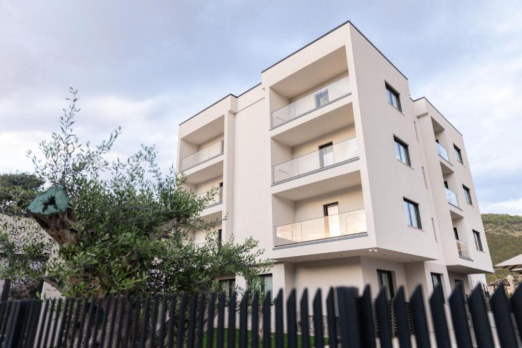 a white building with a fence in front of it at Pauz Hotel in Himare