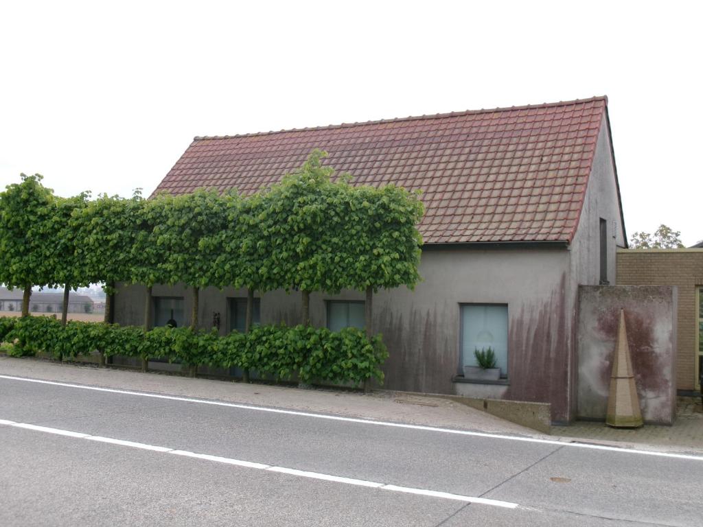 a house with ivy on the side of a street at huisje Kraaiberg in Heuvelland