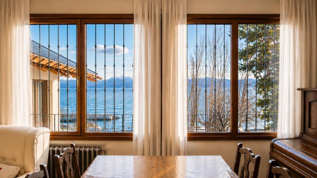 a dining room with a table and large windows at Centrally located lakefront house in San Carlos de Bariloche