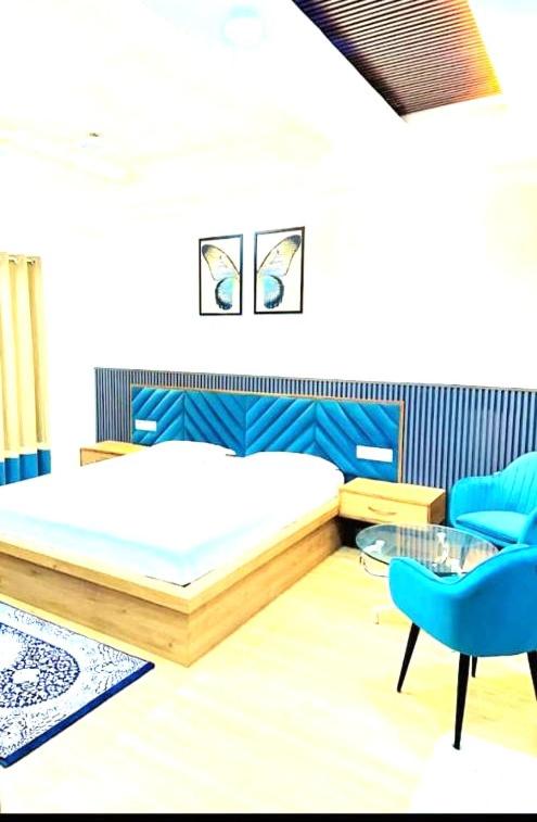 a bedroom with a bed and a blue chair at K D Motels in Patiāla