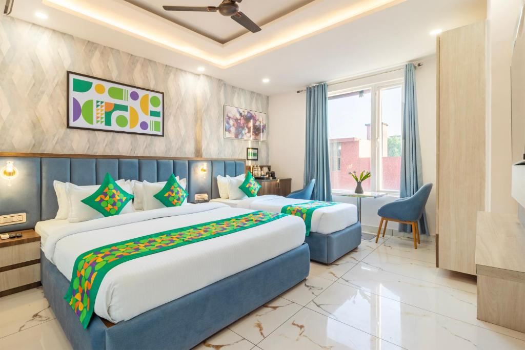 a hotel room with two beds and a window at Treebo Premium Paarth Grand with Pure Veg Restaurant in Haridwār