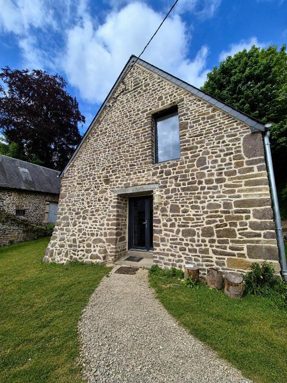 a stone building with a window on the side of it at Gite du Hêtre Pourpre in Clécy