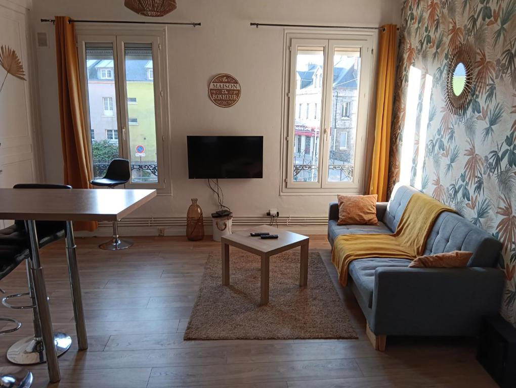a living room with a couch and a table at Au coeur d'Harfleur in Harfleur