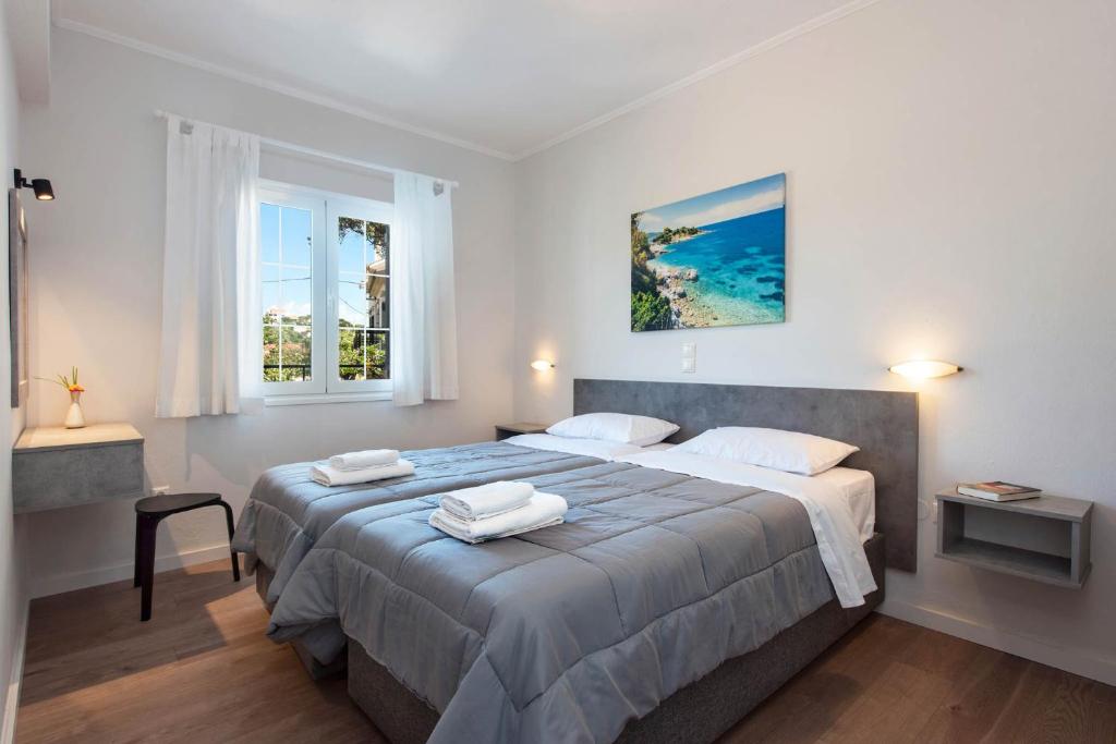 a bedroom with a large bed with two towels on it at Balaris Apartments in Kassiopi