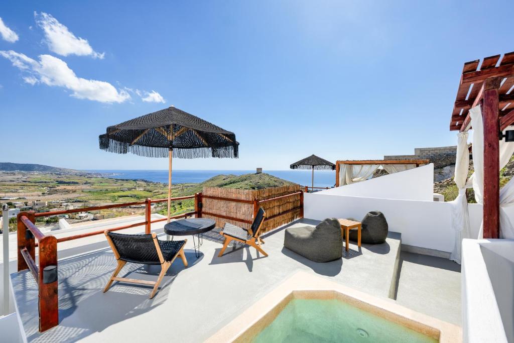a villa with a swimming pool and a view of the ocean at Santorini Rooftop Hot Tub Suite with Panoramic Views in Akrotiri