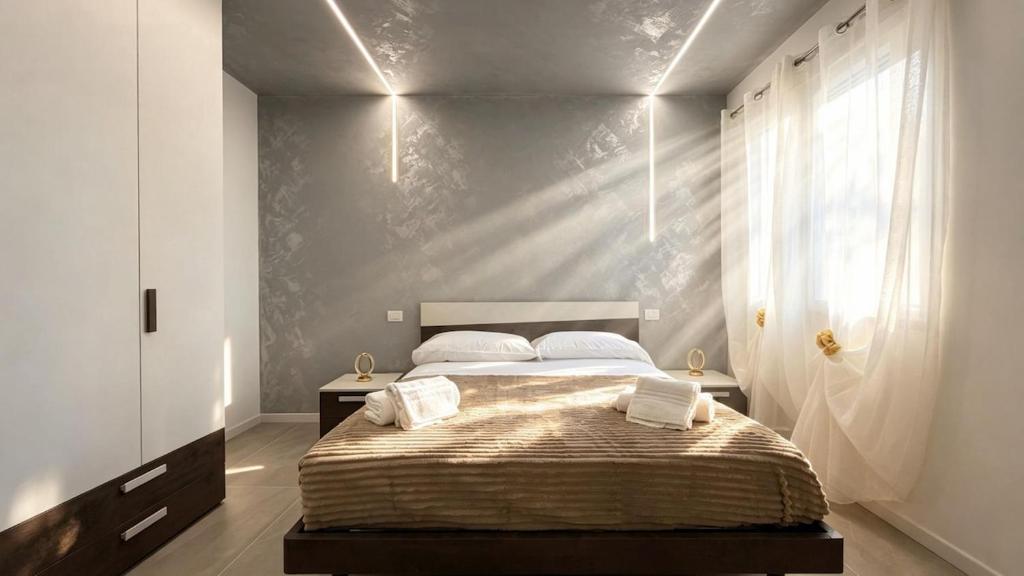 a bedroom with a large bed with two pillows at Casa LIAM & Casa ISABEL in Chioggia