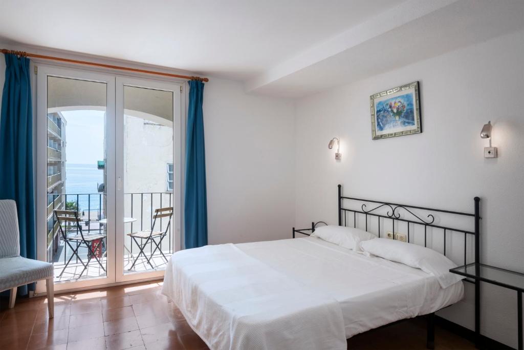 a bedroom with a bed and a balcony at Hotel Caleta in Lloret de Mar