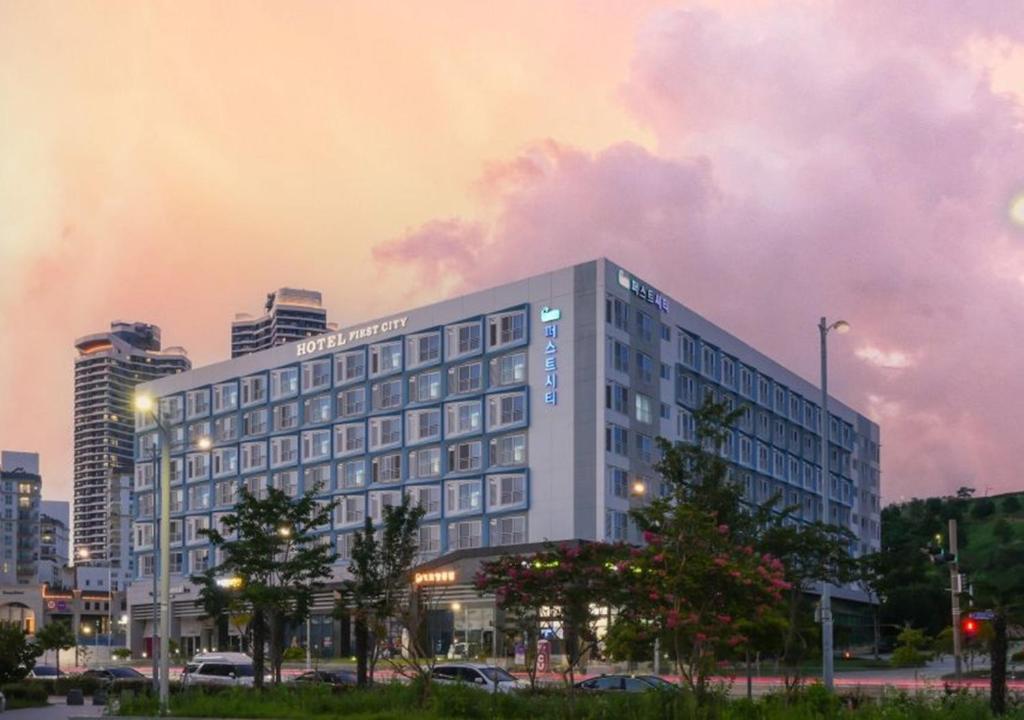 a large building in a city with a cloudy sky at Firstcity Hotel YEOSU in Yeosu