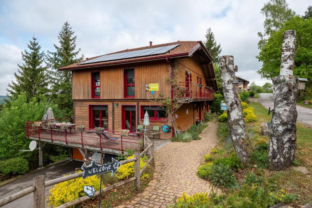 a log house with a porch and a balcony at Gite Nature Ressourcement-Vosges in Le Tholy