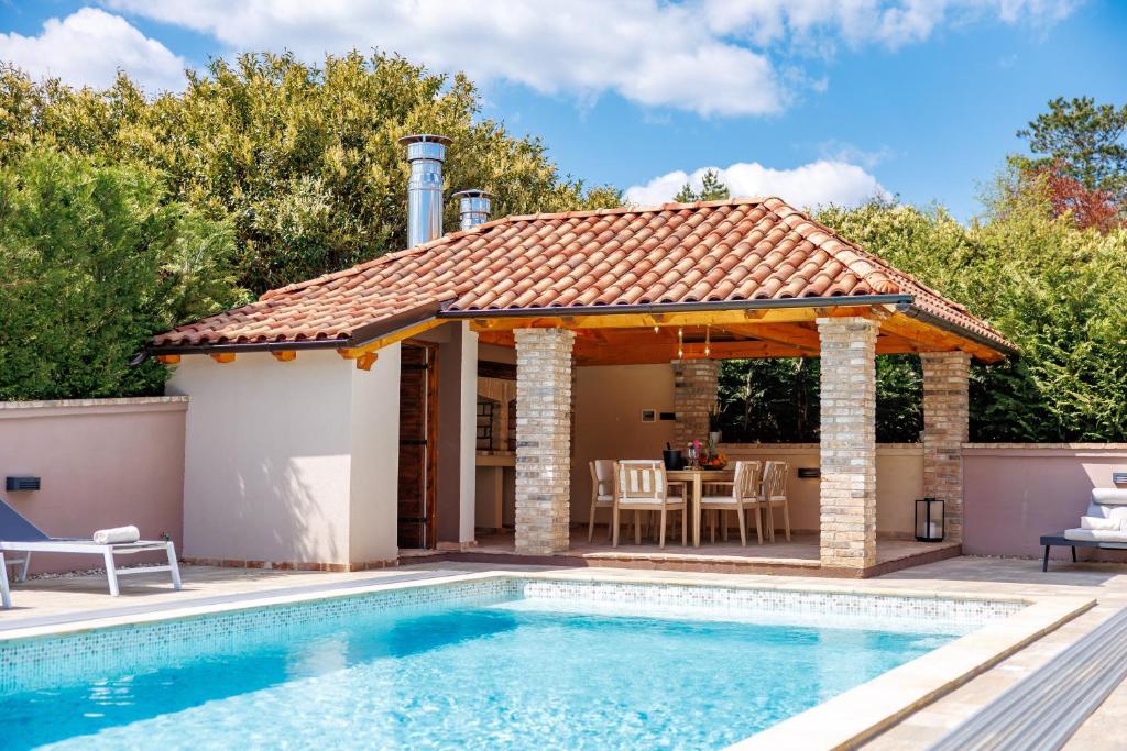 a pool house with a gazebo and a patio at Lux pool Villa Zen - located in peaceful village near Rijeka and Opatija in Klana