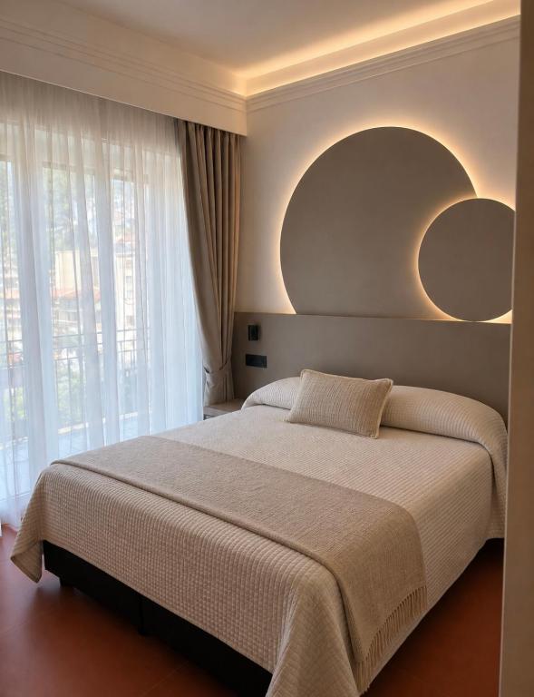 a bedroom with a large bed with two mirrors on the wall at Hotel Sole in Maiori