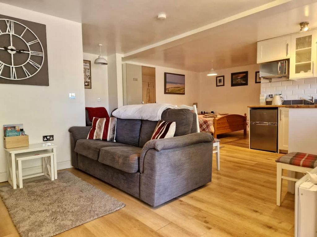 a living room with a couch and a kitchen at The Annexe At The Old Mill in Camborne