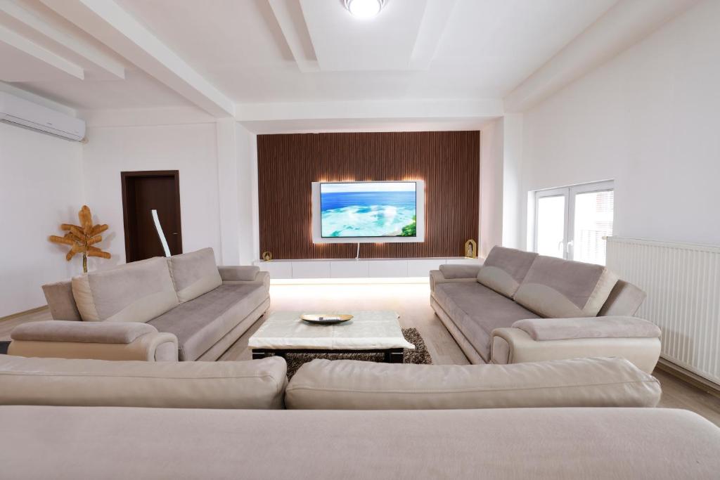 a living room with two couches and a tv at Premium Stay Prishtina in Prishtinë