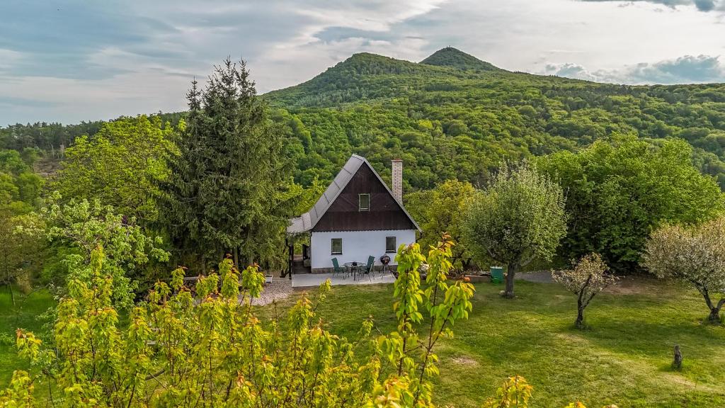 a house in the middle of a field with mountains at Chata obklopena přírodou in Malé Žernoseky