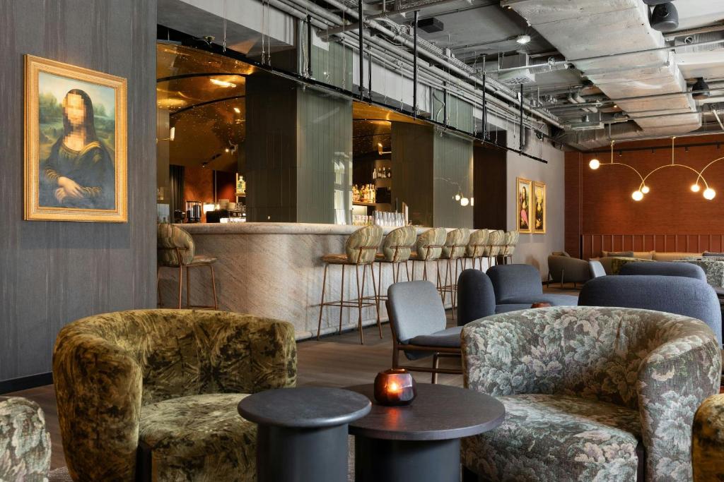 a waiting room with chairs and a bar at The Cloud One Frankfurt-Metropolitan in Frankfurt