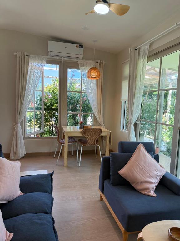 a living room with two blue couches and a table at De 8 Huahin in Ban Nong Chaeng