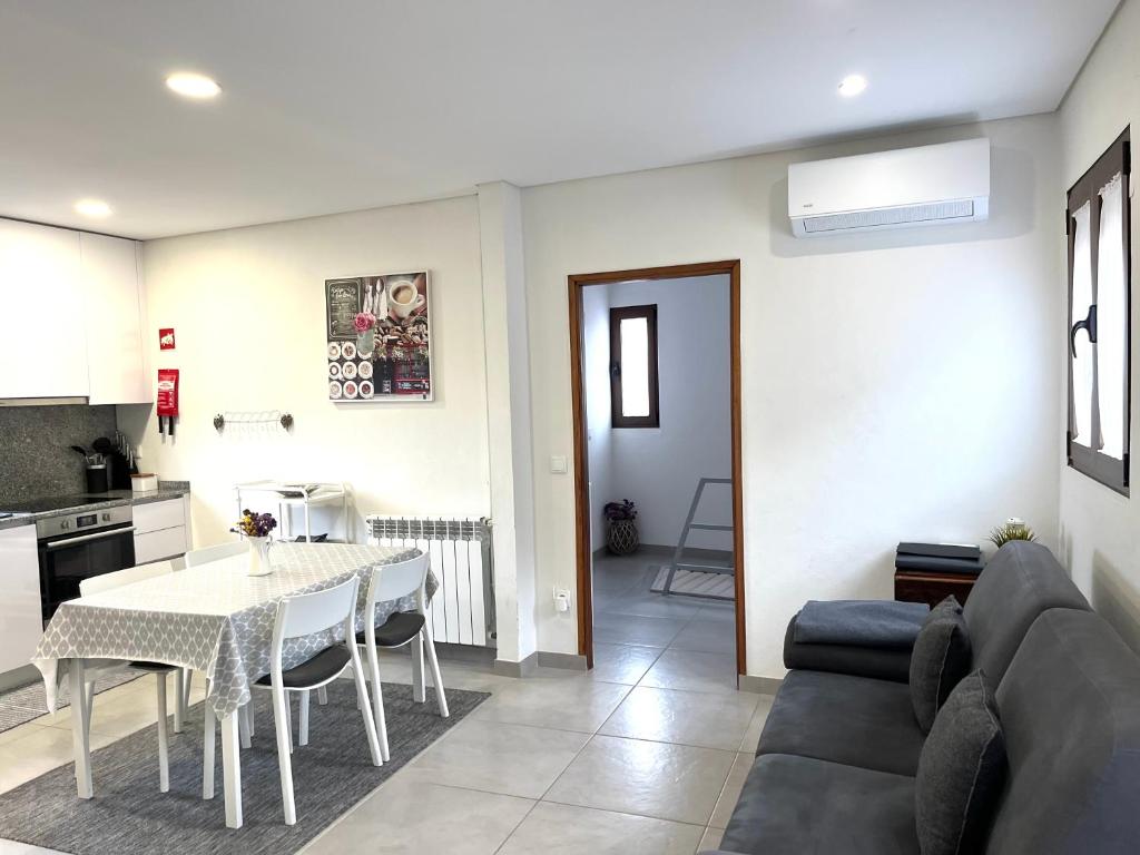 a kitchen and a living room with a table and a couch at Casa da Laija - Vistas rio - "Gerês" in Geres
