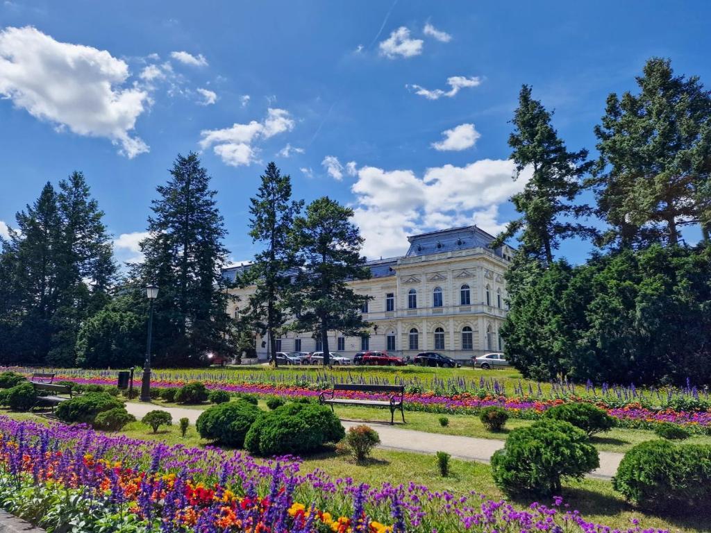 a park with flowers in front of a white building at Łazienki Uzdrowiskowe Nr 1 in Ciechocinek