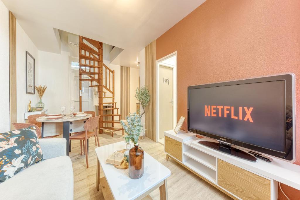 a living room with a flat screen tv at Le splendide - modern & cocooning in Tarbes