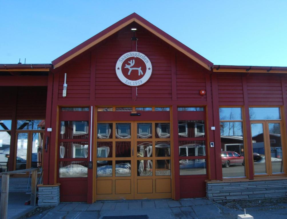 a red building with doors and a sign on it at Saxnäsgården Hotell in Saxnäs