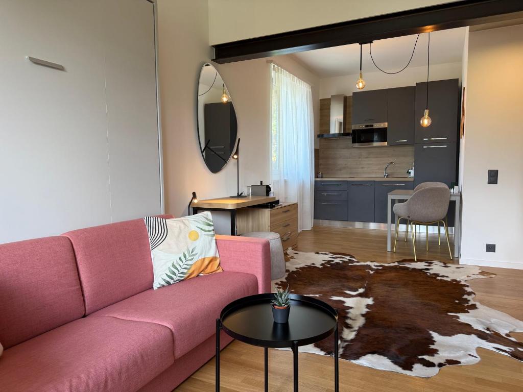 a living room with a pink couch and a kitchen at Appartamento Centovalli e Verzasca in Minusio