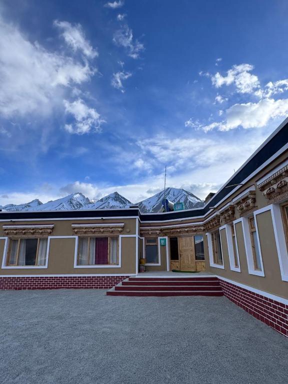 a house with mountains in the background at Ostal Residency Pangong in Meruk