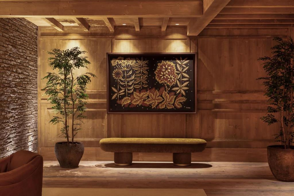 a lobby with a bench and a painting on the wall at MiM Baqueira member of Meliá Collection in Baqueira-Beret