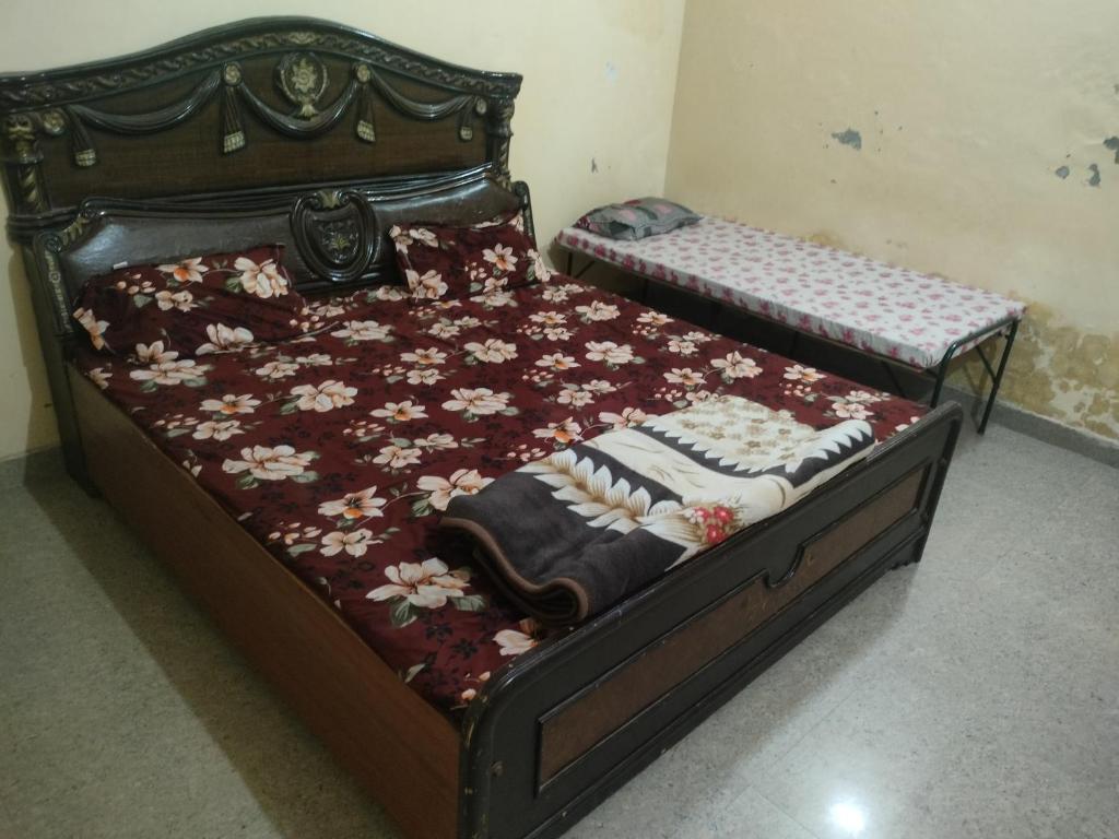 a bedroom with two twin beds with flowers on them at Jp Homestay in Vrindāvan
